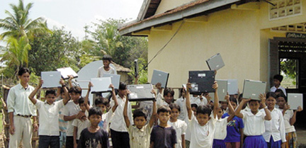 kids outside holding laptops over their heads